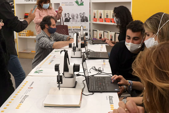Autors internacionals signen llibres a distància per Sant Jordi gràcies a un braç robòtic